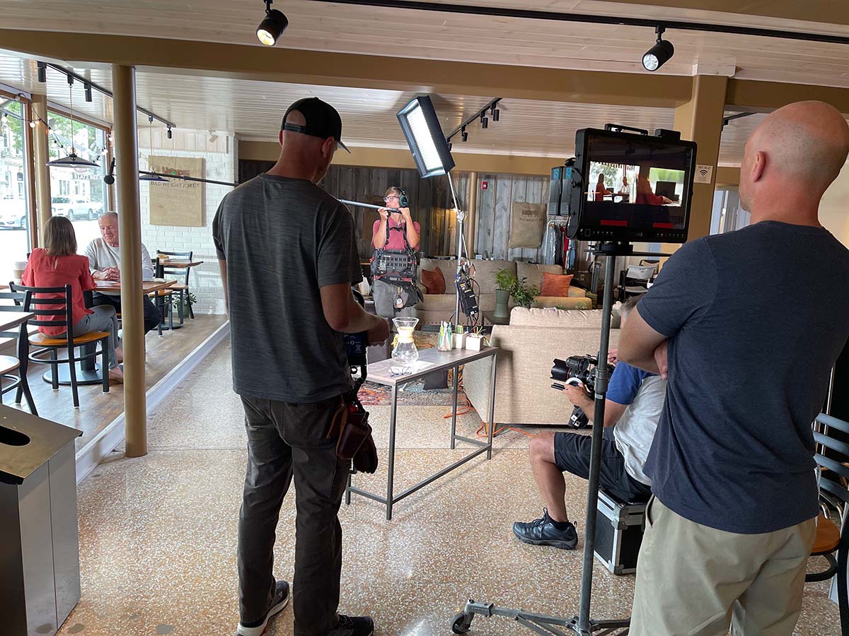 A behind-the-scenes shot of the crew shooting a commercial at a restaurant.